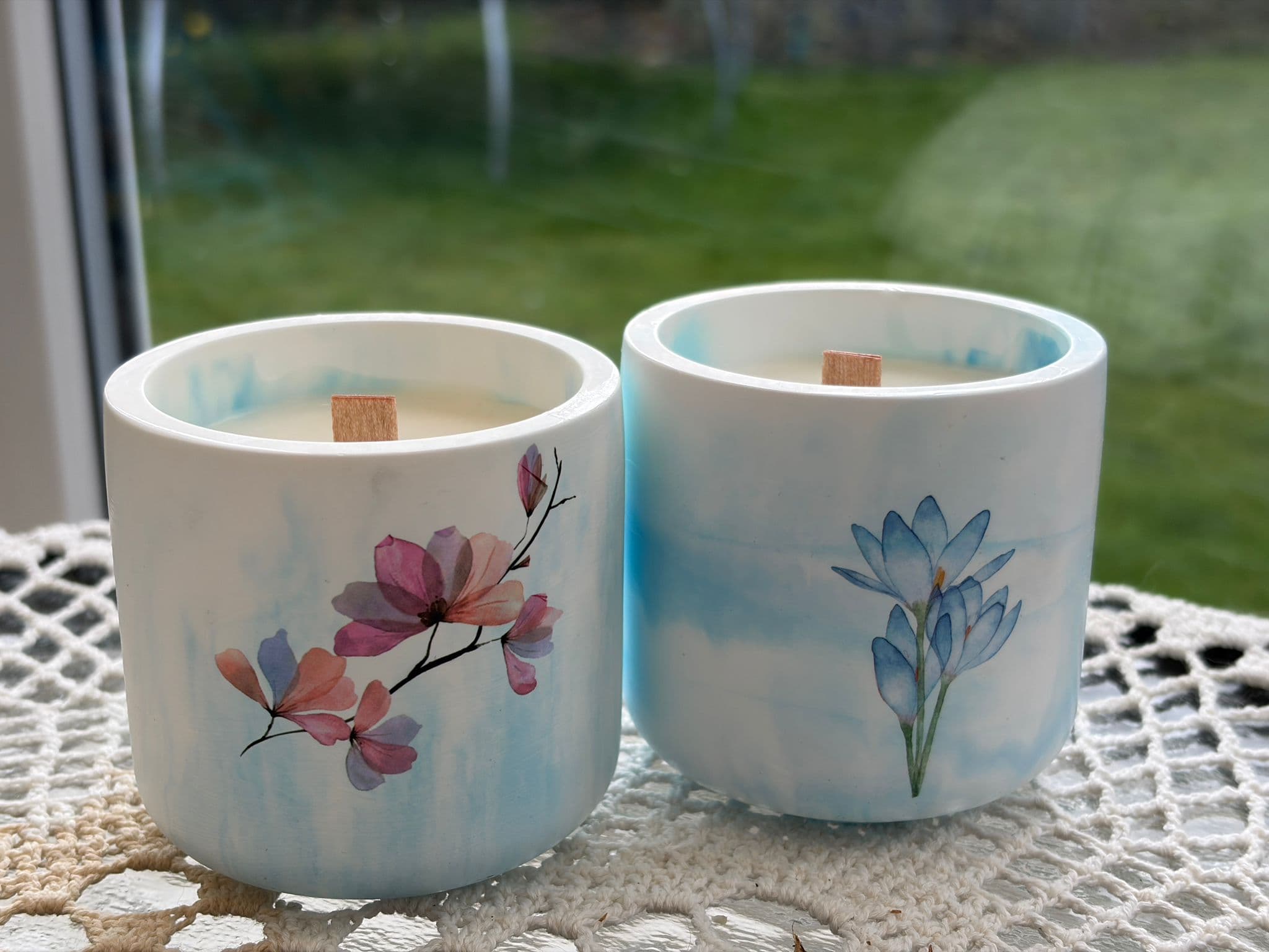 Pale blue and white ceramic candles with blossom and blue flower artwork and wooden wicks