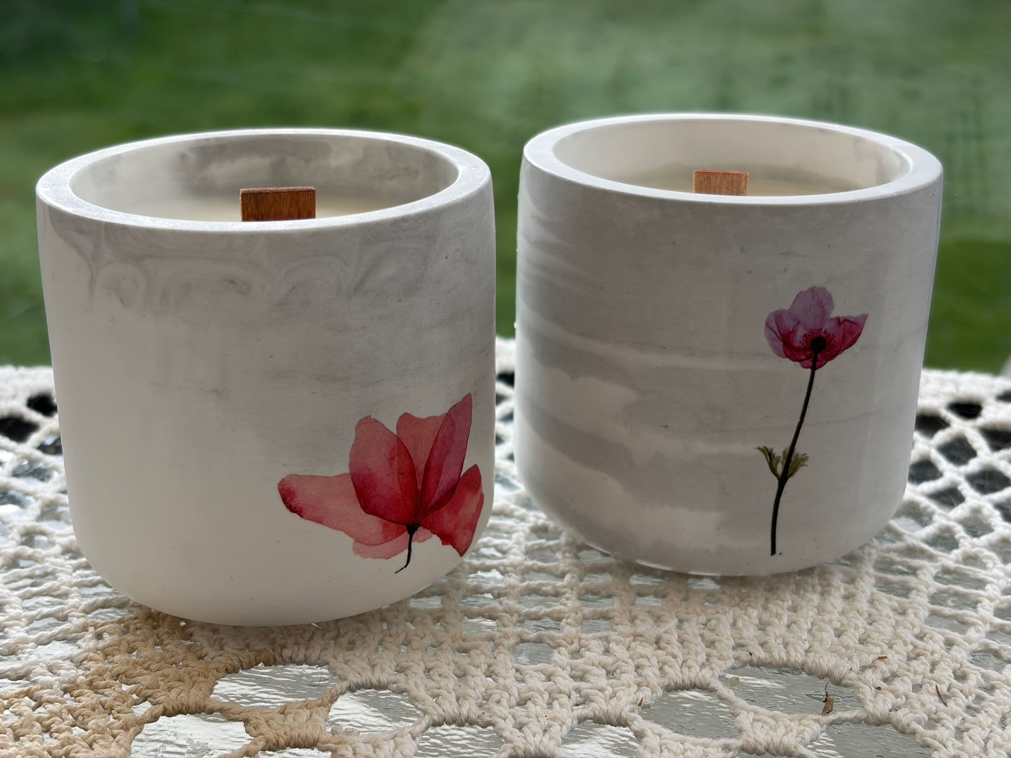 White marbled ceramic candles with pink pressed flower artwork and wooden wicks